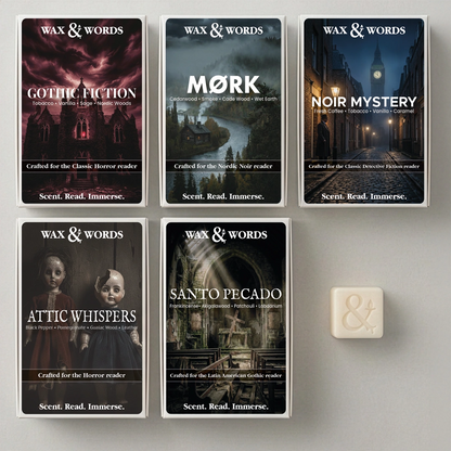 Six boxed card decks from Wax & Words arranged on a light gray surface, plus one small cream-colored card or tile at lower right. The boxes feature dark illustrated covers for Gothic Fiction, Mørk, Noir Mystery, Attic Whispers, Santo Pecado, and a dark gothic title.