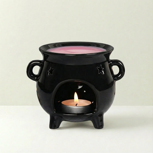 Black ceramic oil burner with a lit candle inside on a white background