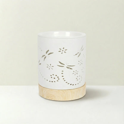 White ceramic warmer with floral cutout design on a beige background