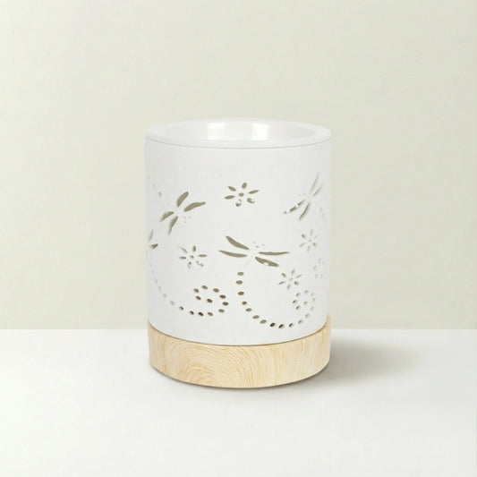 White ceramic warmer with floral cutout design on a beige background
