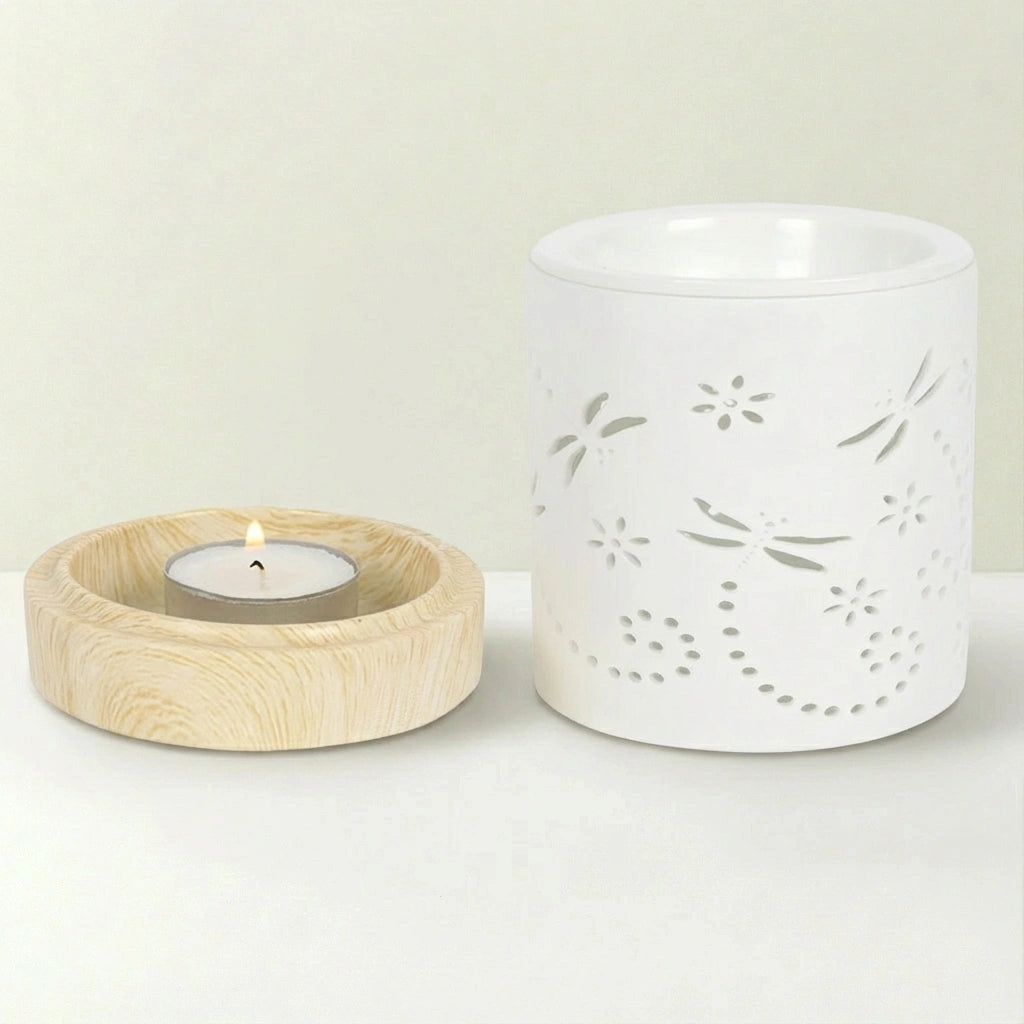 White ceramic diffuser with wooden holder and lit candle on a light background