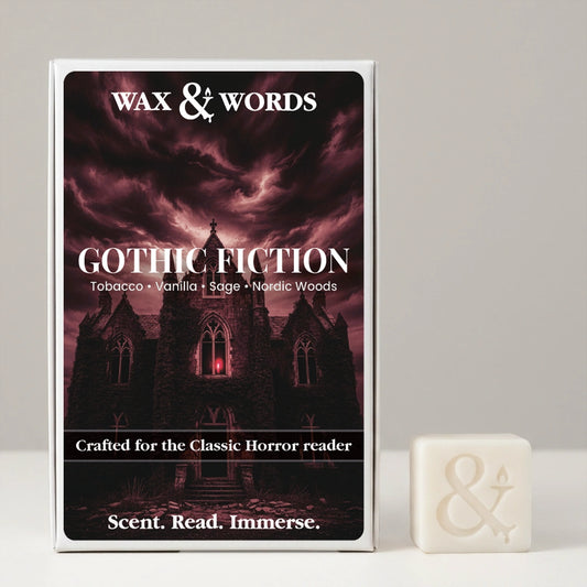 Wax & Words Gothic Fiction scented candle in a white rectangular box with a dark gothic illustration, shown next to a small white candle cube with an ampersand symbol on a light gray background.