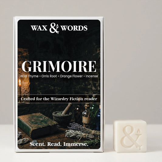 Wax & Words 'Grimoire' fragrance box shown upright next to a small off-white wax cube with an ampersand symbol, on a light gray background.