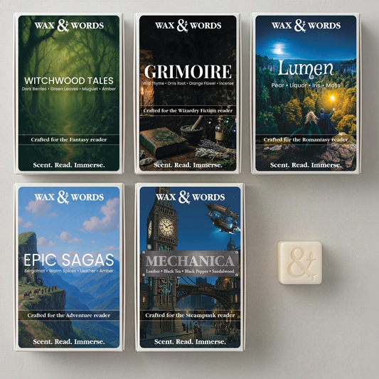 Six Wax & Words board game boxes arranged on a light gray surface, plus one small cream-colored card or tile beside them. The boxes feature fantasy-themed artwork and titles including Witchwood Tales, Grimoire, Lumen, Epic Sagas, and Mechanica.