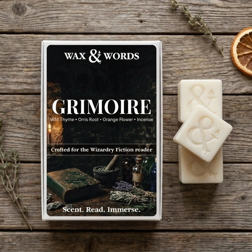 A boxed incense product labeled 'Wax & Words' and 'Grimoire' is displayed on a rustic wooden surface, alongside two cream-colored wax cubes embossed with the brand mark. The scene includes dried herbs and a dried orange slice as styled props.